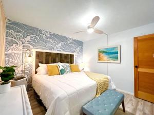 ein Schlafzimmer mit einem Bett mit einer blau-weißen Wand in der Unterkunft Perch - Maalaea Banyan 120 in Wailuku + 25 Fotos