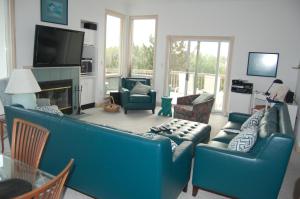 a living room with a blue couch and chairs at M906- Castle De La Mar in Corolla