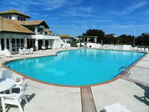a large blue swimming pool with white chairs around it at M906- Castle De La Mar in Corolla
