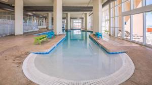 ガルフ・ショアーズにあるPhoenix Gulf Shores 1004の建物の中にある青いテーブルとベンチのある大きな部屋