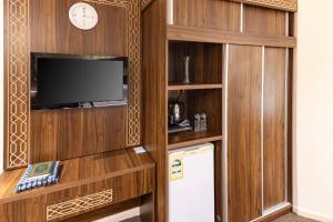 a kitchen with a tv and a refrigerator in a room at Mahd Al Resala 1 Hotel in Mecca