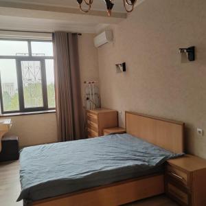 een slaapkamer met een bed en een raam bij 1 bedroom apartment in Doesjanbe