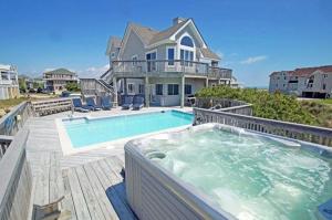 a house with a jacuzzi tub in front of a house at OH1200-Spyglass in Corolla