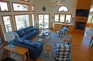 a living room with a blue couch and chairs at OH1200-Spyglass in Corolla