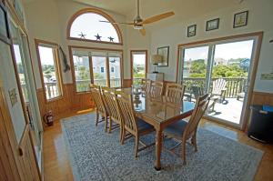 a dining room with a glass table and chairs at OH1200-Spyglass in Corolla