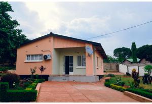 a small house with a driveway in front of it at LYYN Apartments in Chipata