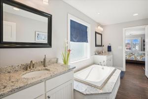a bathroom with a large tub and a sink at CH219C - Southern Jewel in Kill Devil Hills +41 photos