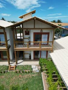 Bangalo Aconchegante - Praia Dulé ES - Suite 1 في غواراباري: منزل مع شرفة وساحة