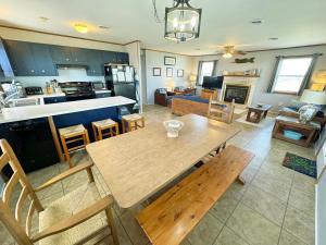 a kitchen and living room with a wooden table and chairs at KD2709- La Dolce Far Niente in Kill Devil Hills