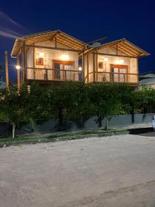 Bangalo Aconchegante - Praia Dulé ES - Suite 1 في غواراباري: منزل مع شرفة فوقه