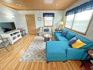a living room with a blue couch and a tv at KH4300- Weather Station in Kitty Hawk