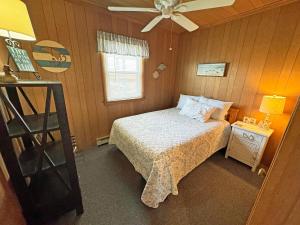 a small bedroom with a bed and a ceiling fan at KH4300- Weather Station in Kitty Hawk +10 photos