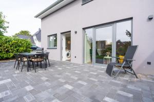 a patio with a table and chairs in front of a house at La Cabane in Laboe