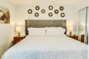 a bedroom with a large white bed with two lamps at 10 A, One Bedroom Condo in Destin