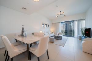 a dining room and living room with a table and chairs at NewArabian Act Two T2 2 BR and 3 BR in Dubai