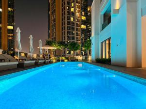 a large swimming pool in a city at night at NewArabian Act Two T2 2 BR and 3 BR in Dubai