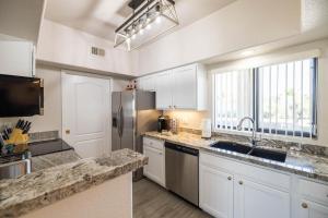 a kitchen with white cabinets and a stainless steel refrigerator at Little Fountain in Fountain Hills