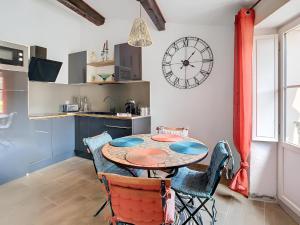 卡尔卡松Vue imprenable cité Carcassonne - 4 personnes的厨房配有桌椅和墙上的时钟