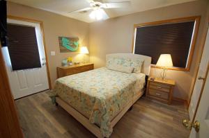 a bedroom with a bed and two night stands and two windows at KH4112-Resting Beach Face in Kitty Hawk +21 photos