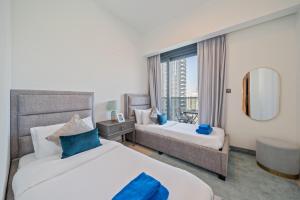 a hotel room with two beds and a window at NewArabian Act Two T2 2 BR and 3 BR in Dubai +89 photos
