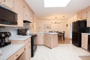 a kitchen with white cabinets and a black appliances at Inglewood Cottage in Saint Thomas