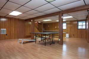a ping pong table in a room with wooden walls at Inglewood Cottage in Saint Thomas