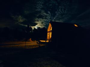 a house lit up in the dark at night at Domki nad Jeziorem Sunia in Świątki
