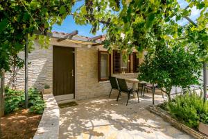 a patio with a table and chairs in front of a house at Elvira - Apartment Bungalow - MPolo in Medulin