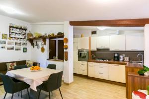 a kitchen and dining room with a table and chairs at Elvira - Apartment Bungalow - MPolo in Medulin