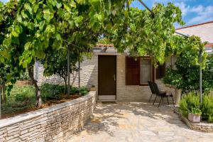 a brick house with a chair in a courtyard at Elvira - Apartment Bungalow - MPolo in Medulin +6 photos