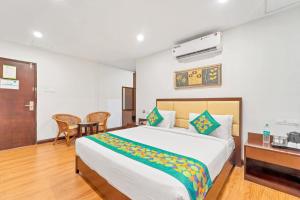 a bedroom with a bed and a table and a desk at Itsy Hotels Adrak in Trivandrum