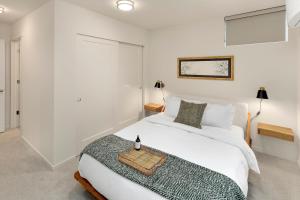 una camera da letto con un letto bianco con un vassoio sopra di Perch - Metro Malden a Seattle