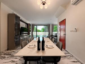 a dining room with a table with two bottles of wine at Dragon Pool Villa Aonang in Ao Nam Mao