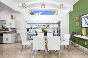 a kitchen and dining room with a glass table and white chairs at Lake House in Miami