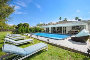 a house with a swimming pool and lounge chairs at Lake House in Miami