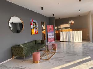 a living room with a green couch and a mirror at Luxury duplex with mountain views, new gudauri in Gudauri