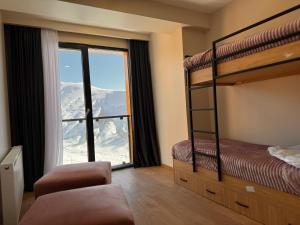 a bedroom with bunk beds and a large window at Luxury duplex with mountain views, new gudauri in Gudauri +9 photos