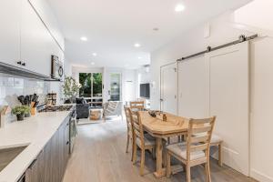 a kitchen and dining room with a wooden table and chairs at Perch - View on Franklin in Seattle