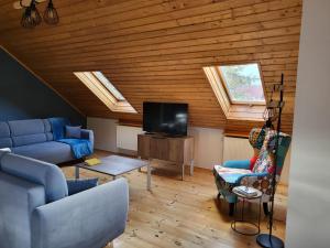 a living room with a blue couch and a tv at VITA MINERALIS Szczawnica in Szczawnica