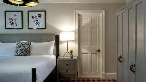 a bedroom with a bed and a lamp and a door at Morrison House Old Town Alexandria, Autograph Collection in Alexandria