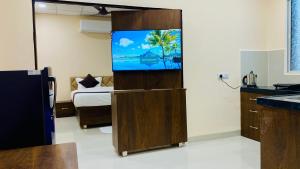a kitchen with a tv in a room with a bed at Stay10 B&M LUXURY ACCOMDATION in Indore