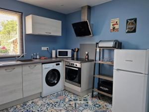a kitchen with a washing machine and a refrigerator at Le loft in Rosult