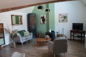 a living room with two couches and a tv at Le loft in Rosult