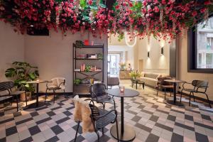 a room with tables and chairs and flowers at Rosa Hotel in Ostend