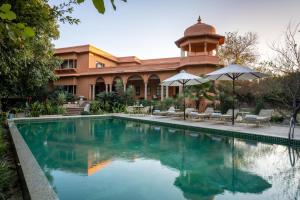 a swimming pool in front of a building at Srinivas The Royal Residence, Jaipur in Jaipur