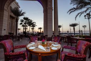 a table and chairs in a restaurant with palm trees at The Ritz-Carlton Jeddah in Jeddah