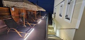 a row of chairs on a balcony with lights at Stellatos House in Poros