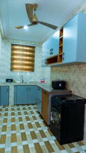 a kitchen with blue cabinets and a black stove at Opheboat Villa and Cuisine Services in Accra