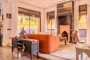 a living room with a couch and a fireplace at Luxury Villa with Pool, Garden & Gated Security in Marrakech