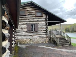 una baita di tronchi con scala e finestra di Alpine Lakeside Manor a Terra Alta